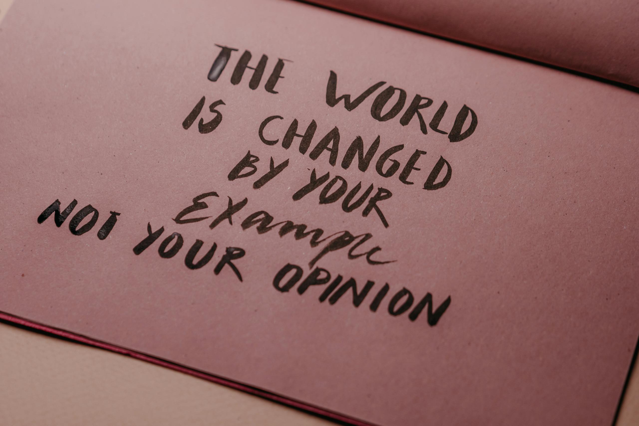 Motivational phrase emphasizing actions over words displayed on textured paper.